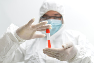Asian male doctor wearing protective suits holding a positive blood test result for the new rapidly spreading Coronavirus (nCoV, Covid-19). International standard biological laboratory concept.