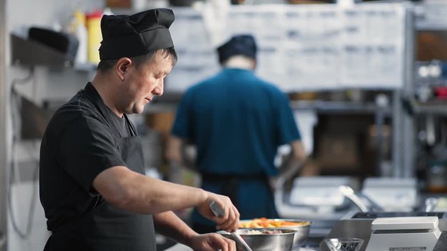 Asian male kitchener mixing dish cooking food at cuisine. Medium close up shot on 4k RED camera