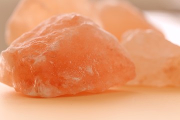 Pink Himalayan salt large pieces set on a light orange blurred background. Saindhava lavana or Himalayan .Pink rock salt.Pink salt minerals in rock from Himalaya