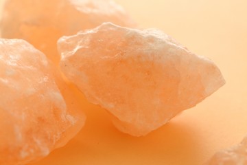 Pink Himalayan salt large pieces set on a light orange blurred background. Saindhava lavana or Himalayan .Pink rock salt.