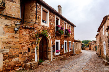Street of the medieval red stone village Castrillo de los Polvazares, Leon, Spain.
