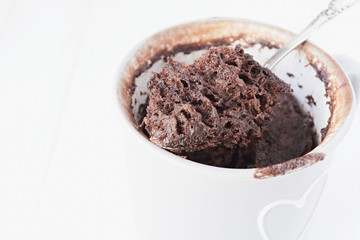 Homemade chocolate mug cake on a white background