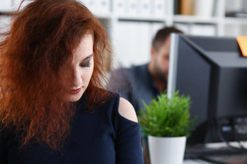 young beautiful red haired woman sit at table in office in cabinet of her boss first place of work concept