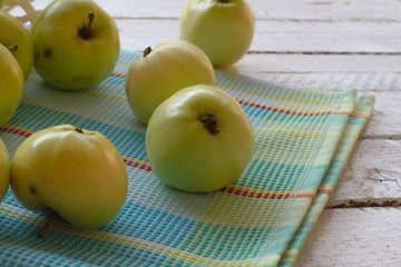 Fresh, ripe Apple harvest. Nature theme with green apples in a white basket on a wooden background. The concept of the nature of the fetus. Top view with space for text