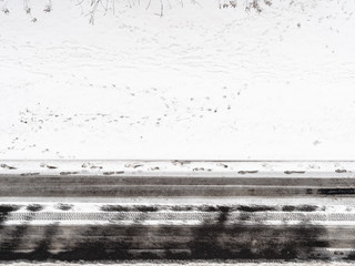 footprints on snow-covered roadside in winter