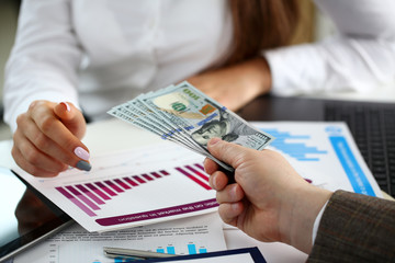 Male arm pay bunch of hundred dollars bills to office clerk closeup. Bribery accept backhander...