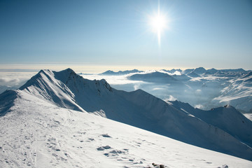 Naklejka na ściany i meble Landscape of snowy mountain top under bright sun