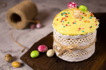 Easter cake on a wooden Board with a candy decoration and topping. Close up