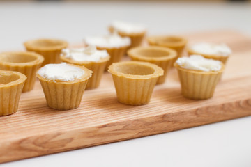 Tartlets with custard or cottage cheese. Empty tartlets or pie on a white table. Food lay flat. The view from the top. The concept of preparing food for the holiday table.