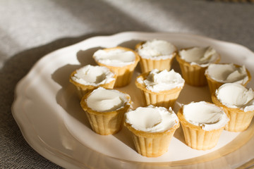 Tartlets with custard or cottage cheese. Empty tartlets or pie on a white table. Food lay flat. The view from the top. The concept of preparing food for the holiday table.