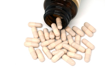 Pink Tablets drug with bottle of medicine isolated white background                                                  