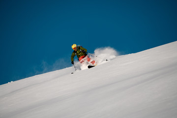 Naklejka na ściany i meble Male skier slides down on the mountain side