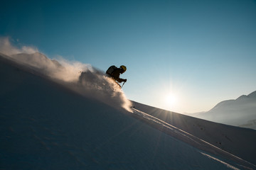 Silhouette of man skier rides down from the snowy hill top - Powered by Adobe