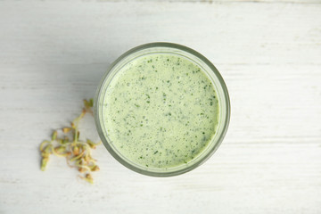 Green buckwheat smoothie on white wooden table, top view