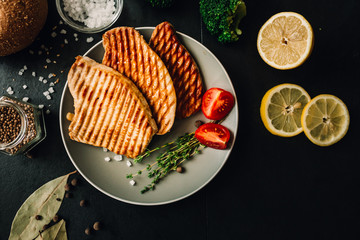 Barbecue fried meat, with ingredients on the table: seasonings, vegetables and spices. View from above.