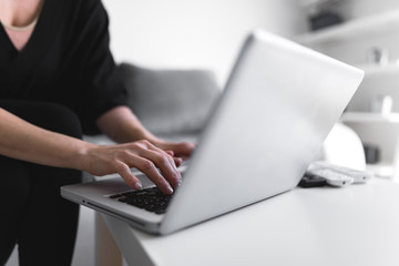 Person using laptop and typing on a keyboard.