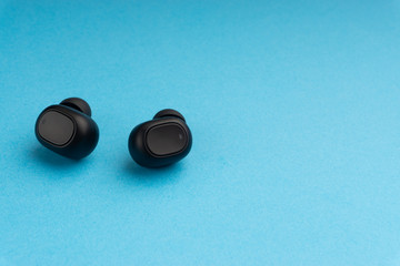 Wireless earbuds or earphones on blue background