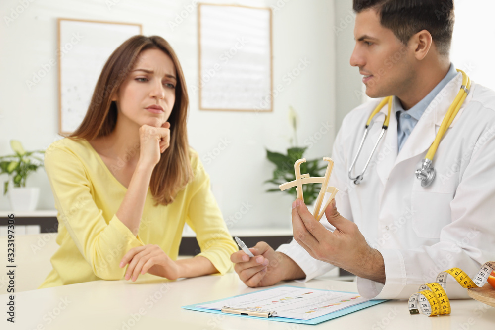 Sticker Nutritionist consulting patient at table in clinic, focus on hands