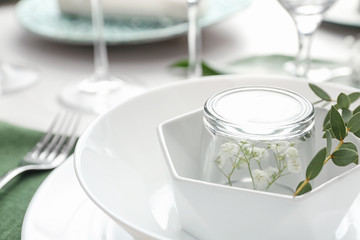 Stylish tableware with green leaves on table, closeup. Festive setting