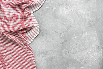 Checkered kitchen towel on gray concrete background. Top view, flat lay, copy space.
