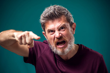 A portrait of angry bearded man pointing finger at camera. People and emotions concept