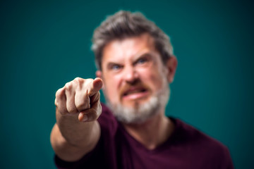 A portrait of angry bearded man pointing finger at camera. People and emotions concept