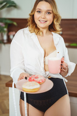 Attractive young female person demonstrating colorful donuts