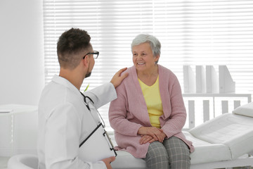 Fototapeta premium Doctor examining senior patient in modern office
