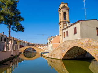 Fototapeta na wymiar Canali e ponti a Comacchio, Emilia Romagna, Italia, con cielo blu senza nuvole
