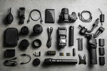 Flat lay composition with camera and video production equipment on light grey stone background - Powered by Adobe