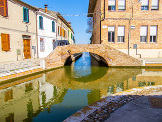 Obraz na płótnie Canvas Canali e ponti a Comacchio, Emilia Romagna, Italia, con cielo blu senza nuvole