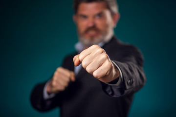Man in suit showing fists at camera. Business and emotions concept