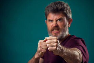 A portrait of bearded angry man showing fist at camera. Peopel and emotions concept