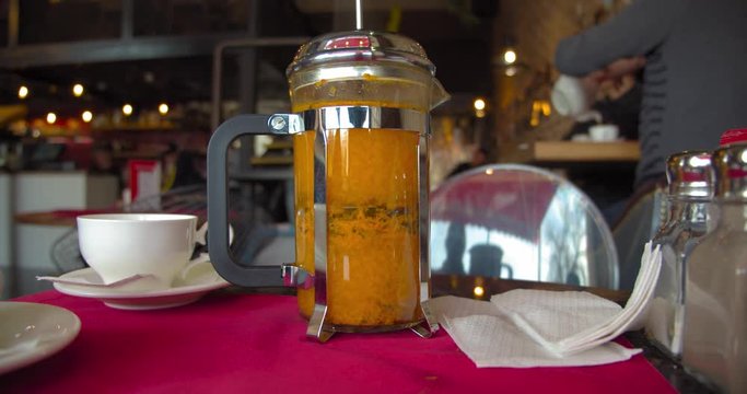 Bright yellow sea buckthorn tea is brewed in a french press teapot. Coffee shop. BMPCC4K