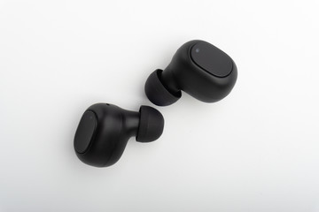 Wireless earbuds or earphones on white background. Copy space and technology concept