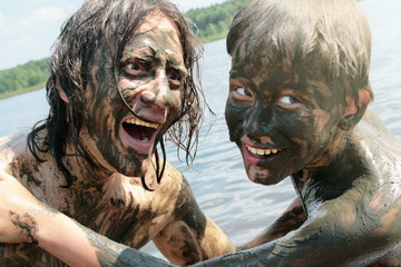 Father and son indulge and have fun in the healing mud. Russians