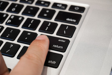 Obraz premium finger on the keyboard return and enter