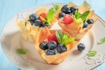 Tasty phyllo cups with blueberries, raspberries and whipped cream