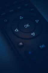 Fototapeta premium Remote control close-up. Dark blue tone. Focus on the center.