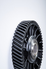 Black polymer gear camshaft with metal base. New spare part for an internal combustion engine on a gray background