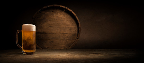 Old oak barrel on a wooden table. Behind blurred dark background.