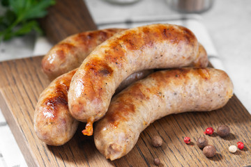 Grilled sausages on a wooden Board on a light gray kitchen table