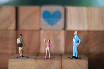 Miniature people happy family dad, mom and children with heart shape background