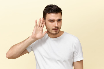 Secrecy and conspiracy concept. Isolated image of snoopy nosy handsome young guy with stubble...