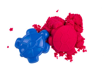 Kinetic sand with molds on a white background, top view