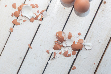 Brown egg shells on wood. Egg shell after cleaning.