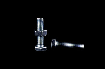 Bolts and nuts on black background close up
