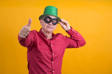 smiling man with black mask, and hat making ok gesture, carnival concept