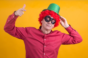 smiling man with black mask, wig and hat, happy carnival concept