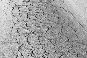 Texture of gray cracked asphalt. Abstract backdrop for design.